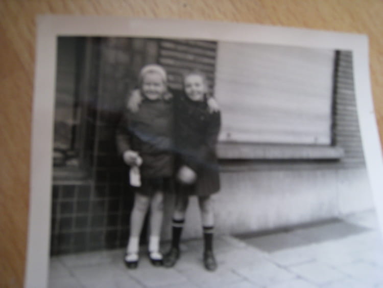 Photo de classe 2 amies devant l'entrée de la maison d'un prof